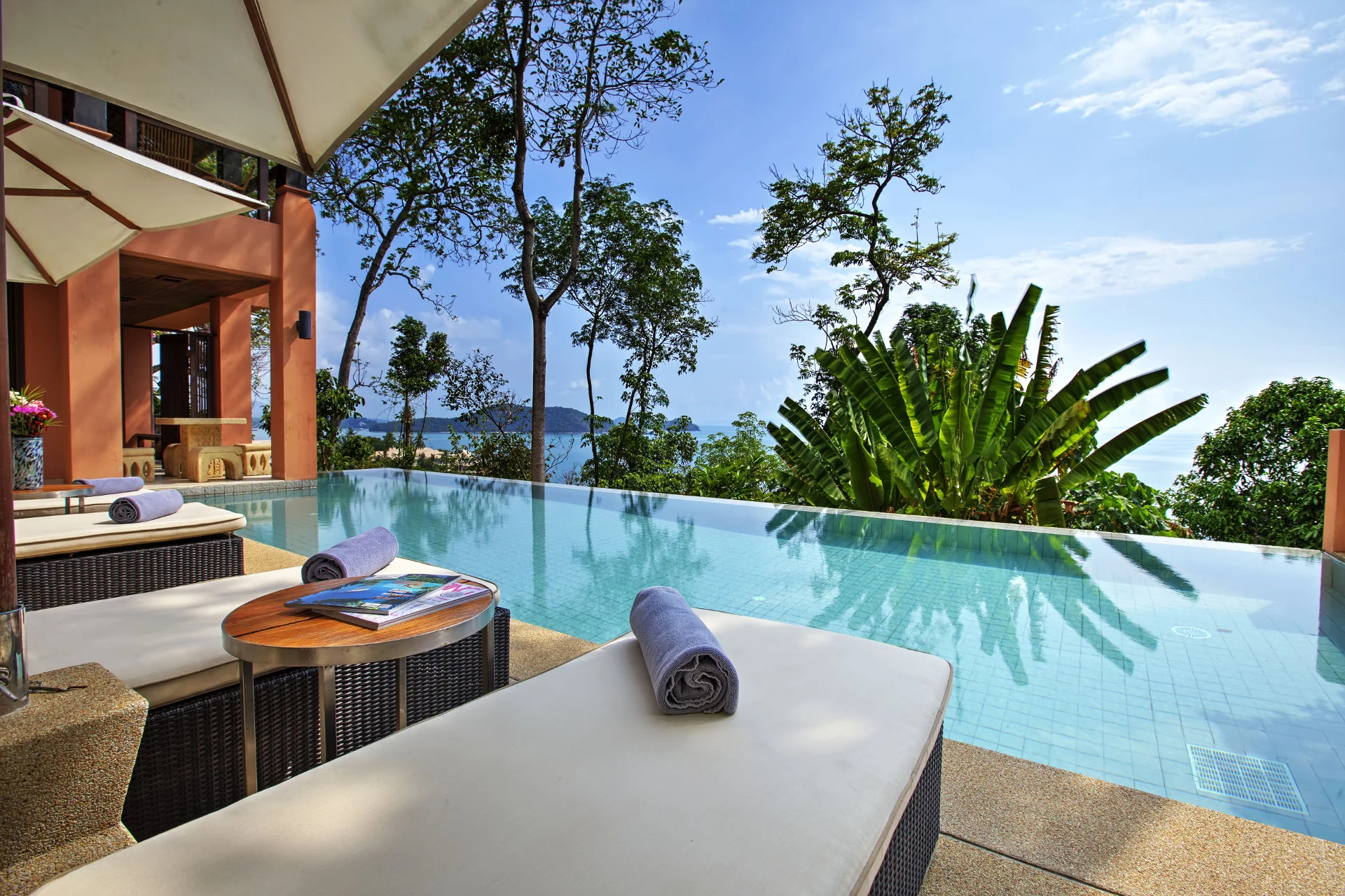Infinity pool surrounded by family, sun loungers and sea views